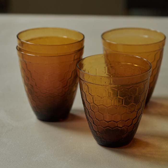 Four honeycomb textured round amber glass tumblers