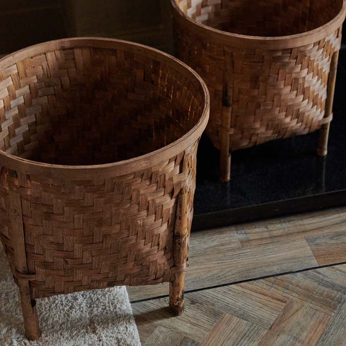 Two woven baskets sat on four bamboo pedestals
