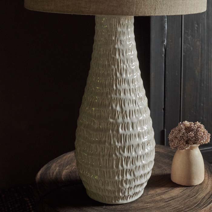 A closeup of the textured detail on the teardrop shaped ceramic base of the Aspal Table Lamp.