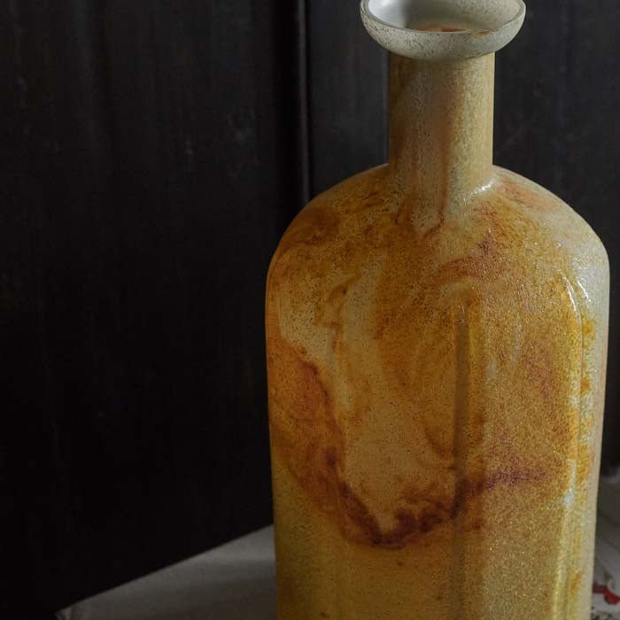 Orange marbled glass vase with a tall bottle shaped neck. Tall bottle vase to add a unique style to your home. Ideal for styling single faux flowers.