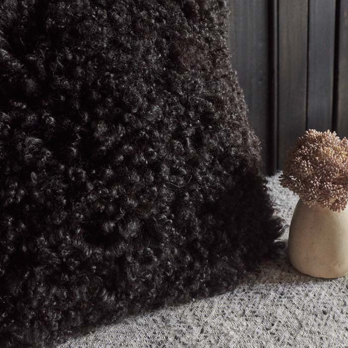 Shaggy texture on a black sheepskin cushion