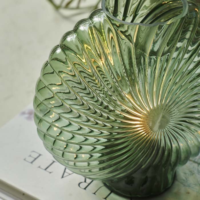 Detail image of a green, shell shaped portable lamp.