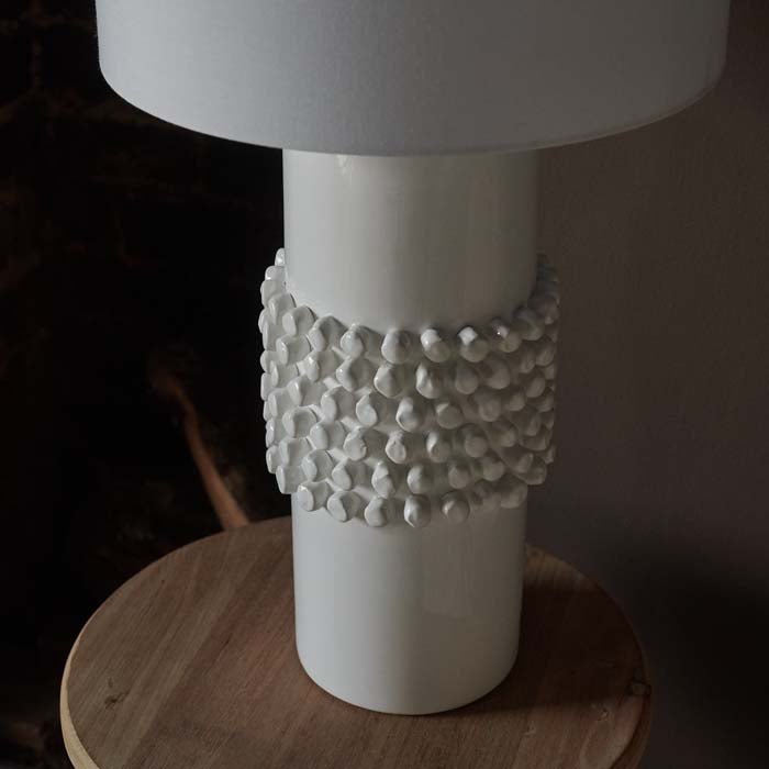 Dotted spikey texture around the centre of a white lamp base