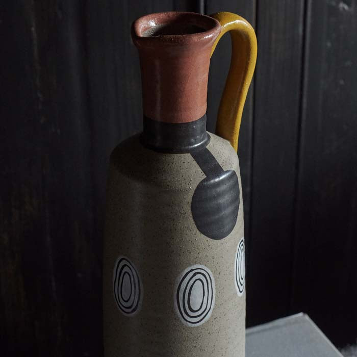 Red neck and handle of a brown ceramic vase shaped like a jug