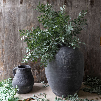 Artificial eucalyptus foliage in blue-grey colour, displayed in large grey stoneware vessel.