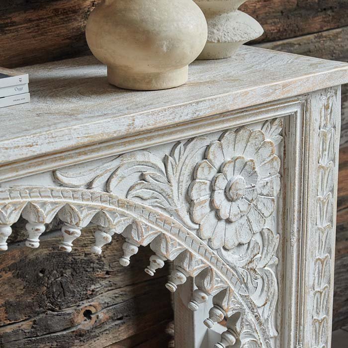 A closeup of the elaborately carved front of the Karnata Carved Console.