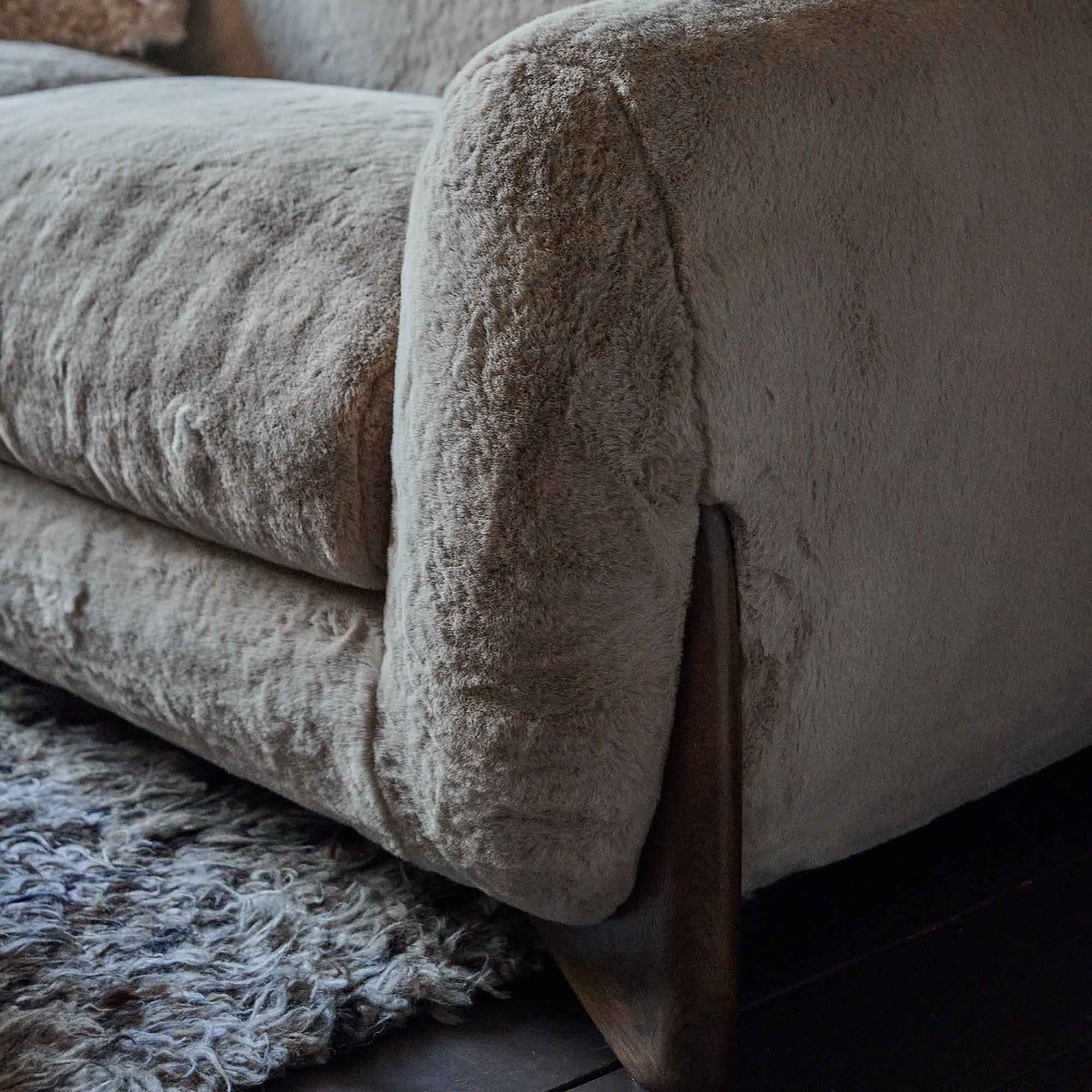 A closeup of the cream coloured soft faux fur upholstery of the Moritz Faux Sheepskin Sofa.