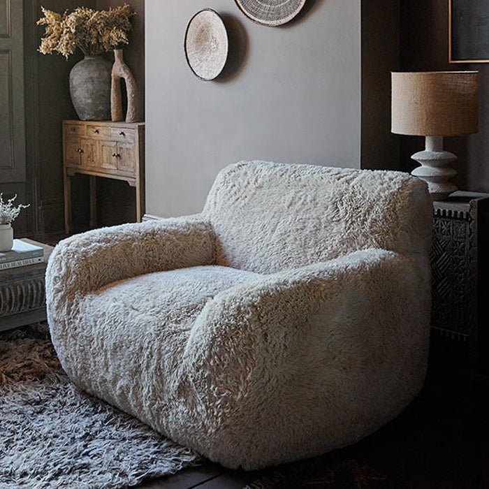 Cream faux fur armchair with an oversized cushioned design, soft textured upholstery and a relaxed curved silhouette. Saskia Cream Faux Fur Armchair by Abigail Ahern, created for ultimate comfort with a cosy statement look that adds warmth and texture to modern interiors. A luxury accent chair perfect for living rooms, bedrooms and reading corners, bringing timeless style, inviting comfort and a sophisticated focal point to contemporary home decor.