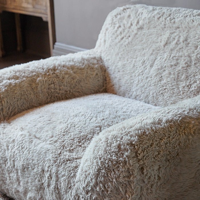 A closeup of the soft cream faux fur upholstery of the Saskia Armchair.