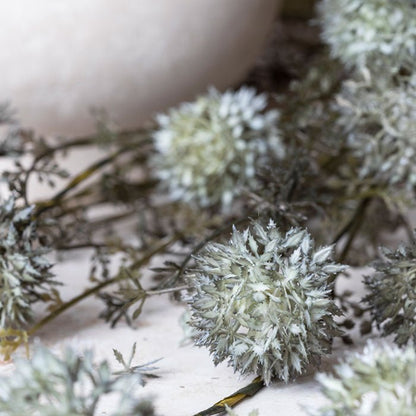 Detail image of the faux flower heads made of spiky flower petals in a soft grey green colour