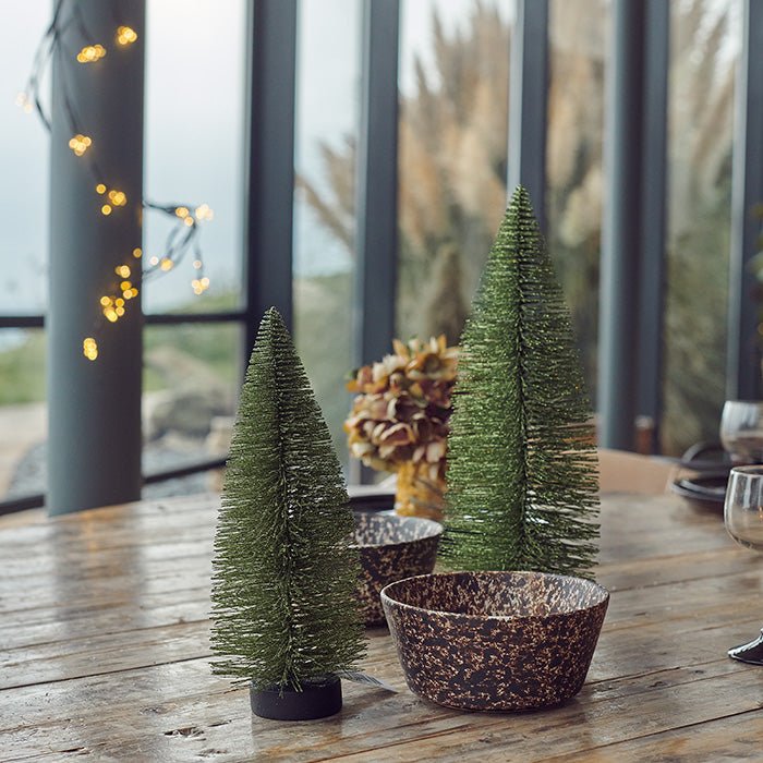 Decorations that resemble small Christmas trees displayed on a table.