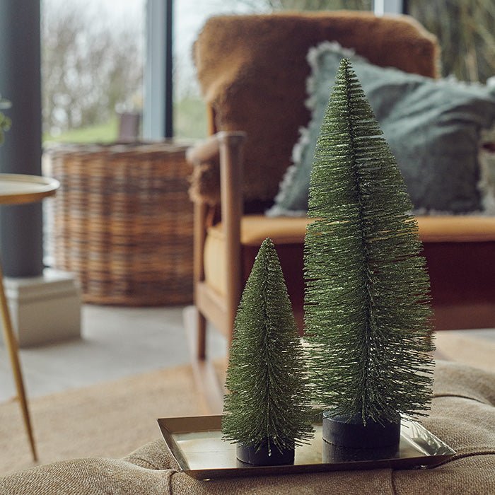 Two green, brush-like decorations that resemble small Christmas trees.
