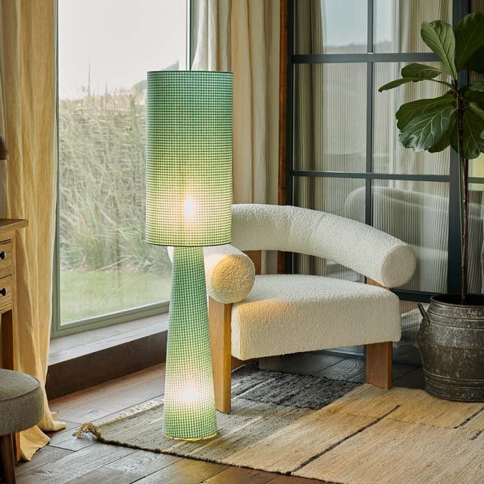 Rylan Floor Lamp - Green Gingham, a tall slim cylindrical floor lamp in green gingham fabric, next to a cream boucle chair.