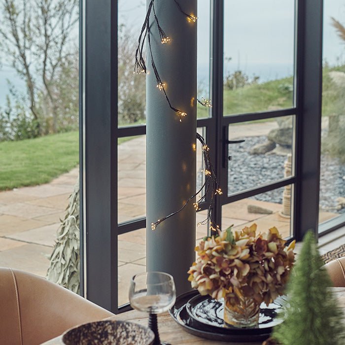 A wired string light wrapped around a column in the home.