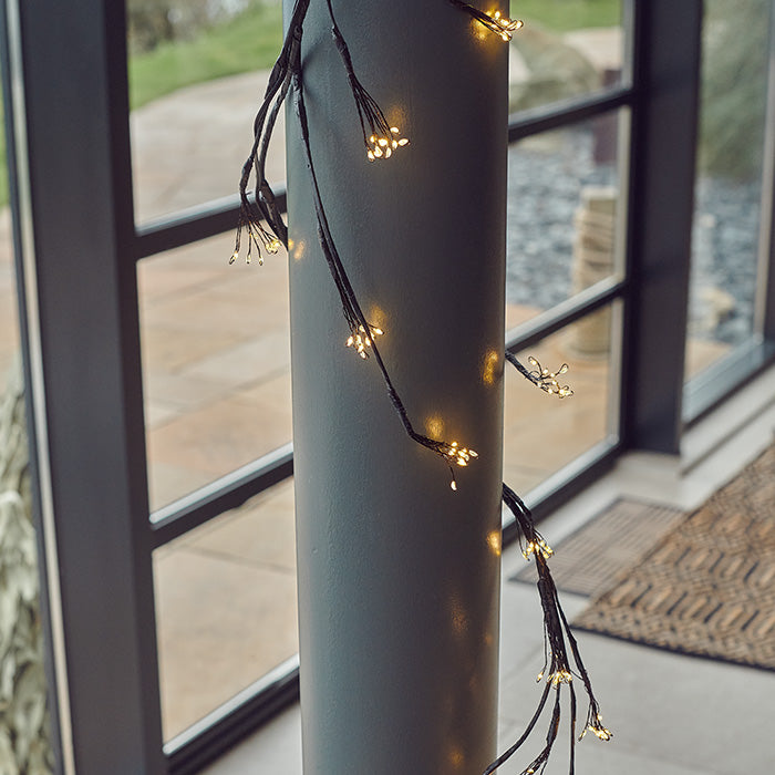 A wired string light wrapped around a column in the home.