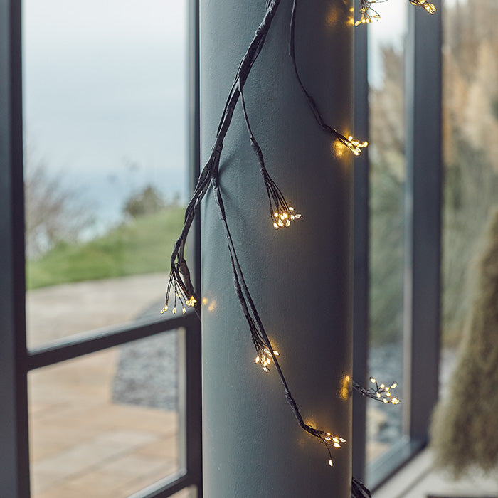 A wired string light wrapped around a column in the home.