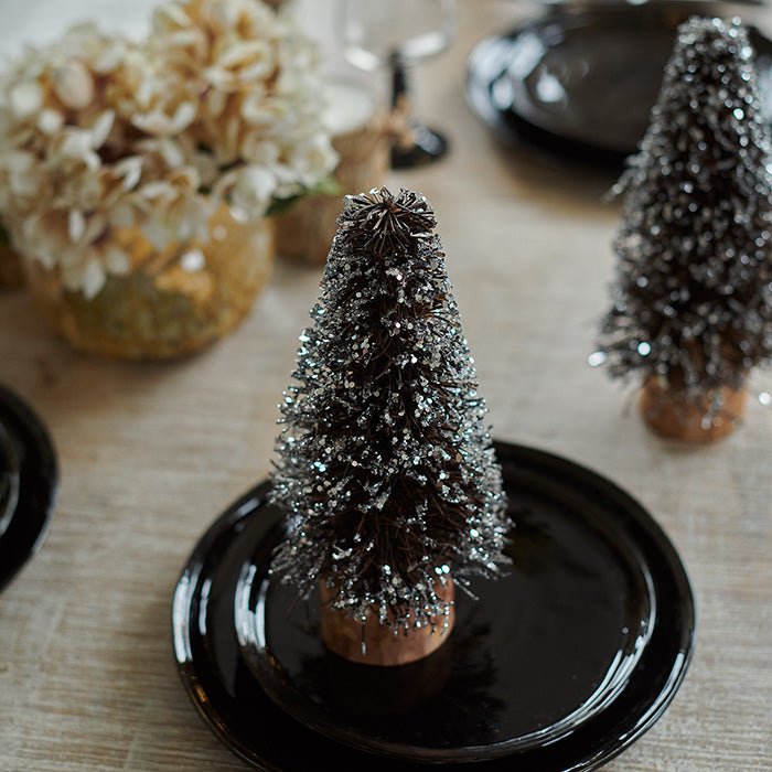 Small decorative Christmas trees covered in glitter.
