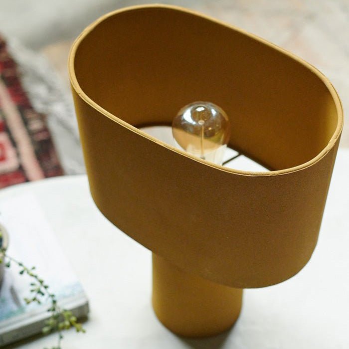 Detail image of the curved rectangular shade on a yellow table lamp.