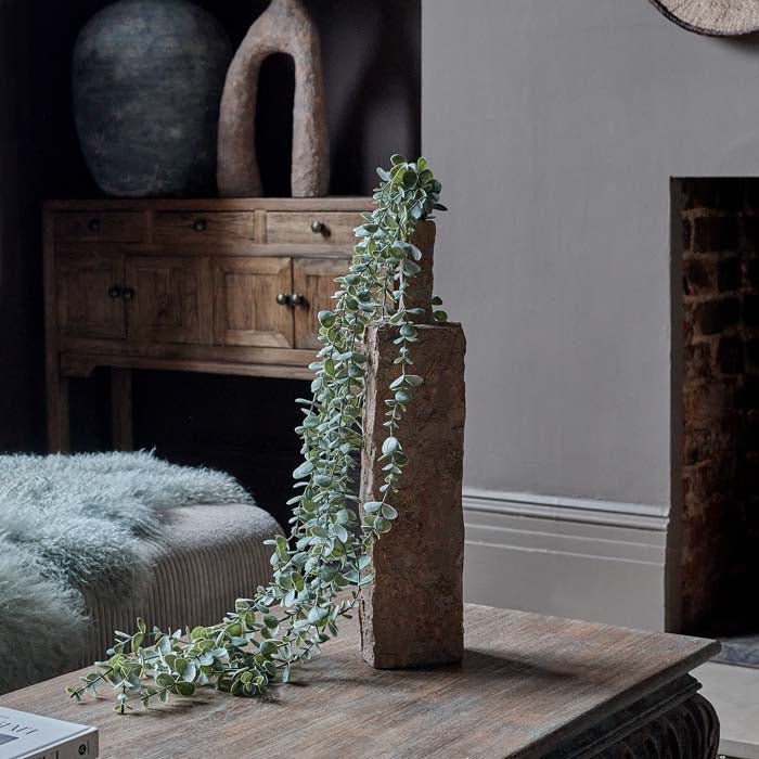 Styled image of artificial green eucalyptus coming out of a ceramic vase. Shop luxury artificial plants and premium ceramic vases from interior designer Abigail Ahern.