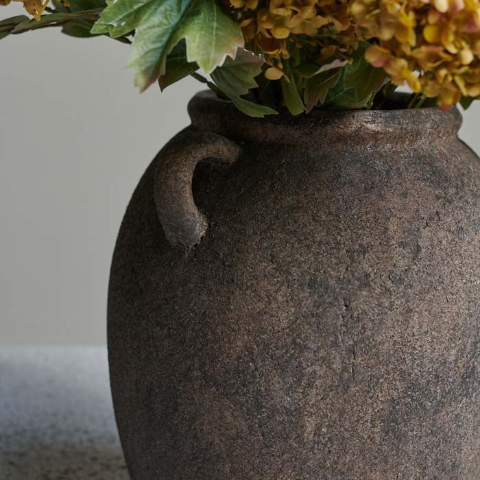 A closeup of the rustic brown mottled surface of the Isador Vase.
