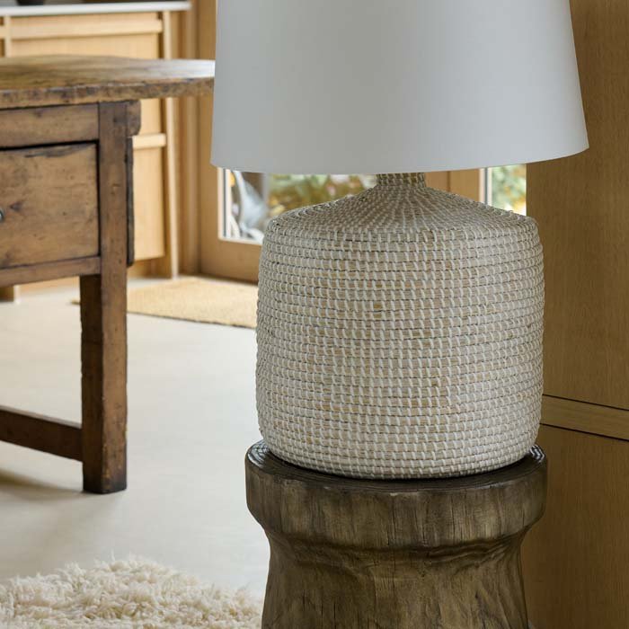The Devoran Seagrass Lamp, a table lamp with a chunky cylindrical base made from natural seagrass and a white drum shade.