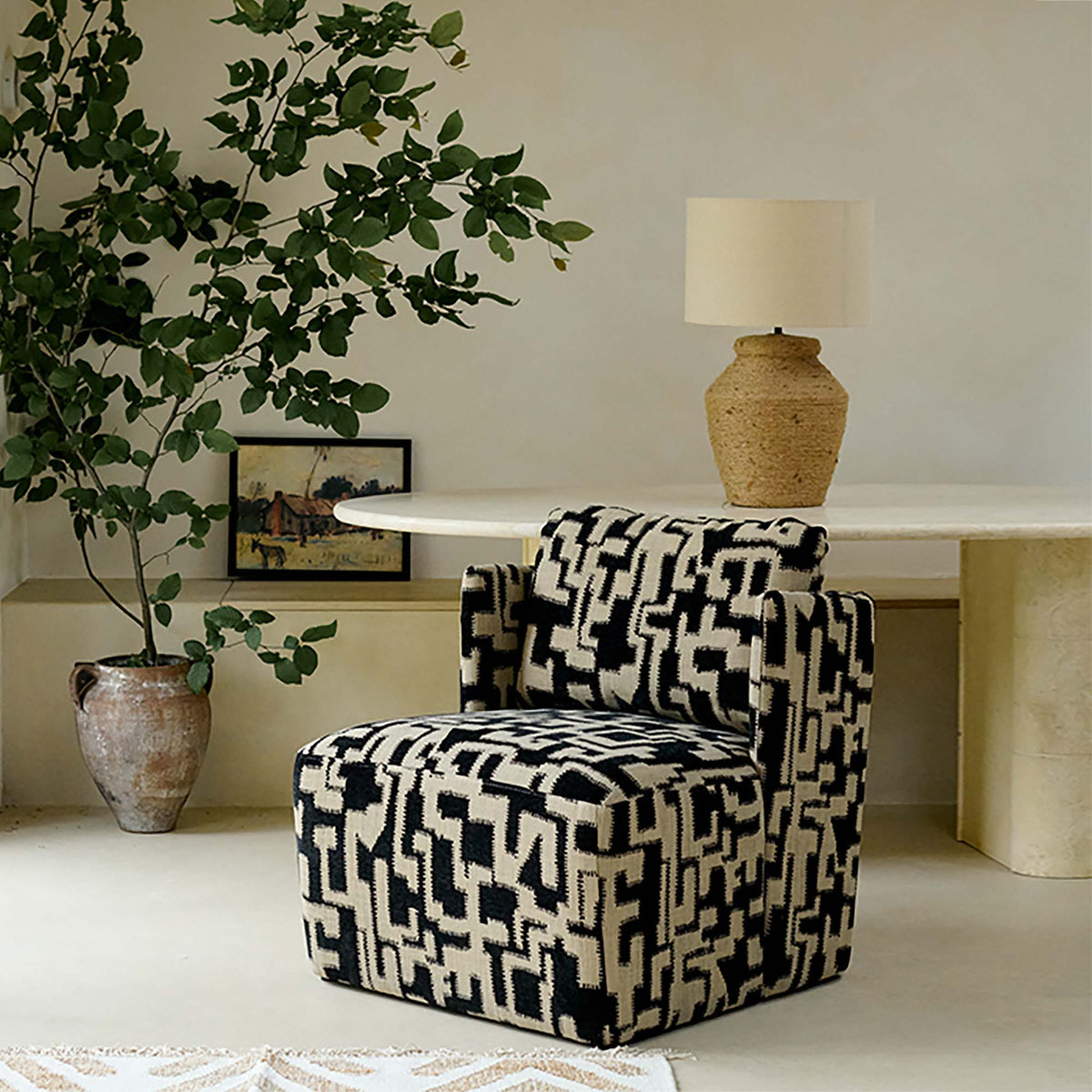 Black and beige patterned armchair with an abstract geometric print, plush upholstered seat and contemporary boxy silhouette. Dulwich Patterned Armchair by Abigail Ahern, designed as a bold statement accent chair that adds personality and texture to modern living rooms, bedrooms and stylish interiors. A luxury occasional chair perfect for creating a designer focal point, combining comfort, pattern and timeless contemporary style in your home decor.