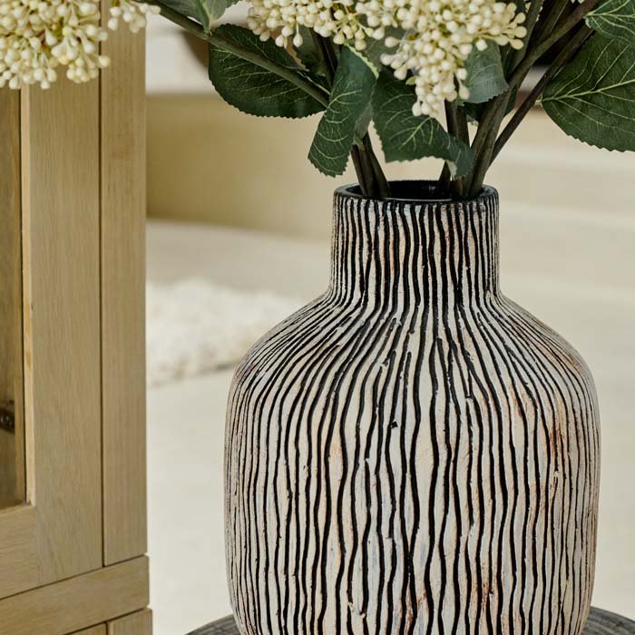The Sahara Earthenware Vase, a large bottle shaped stone coloured vase with vertical asymmetric stripes and a rustic look.