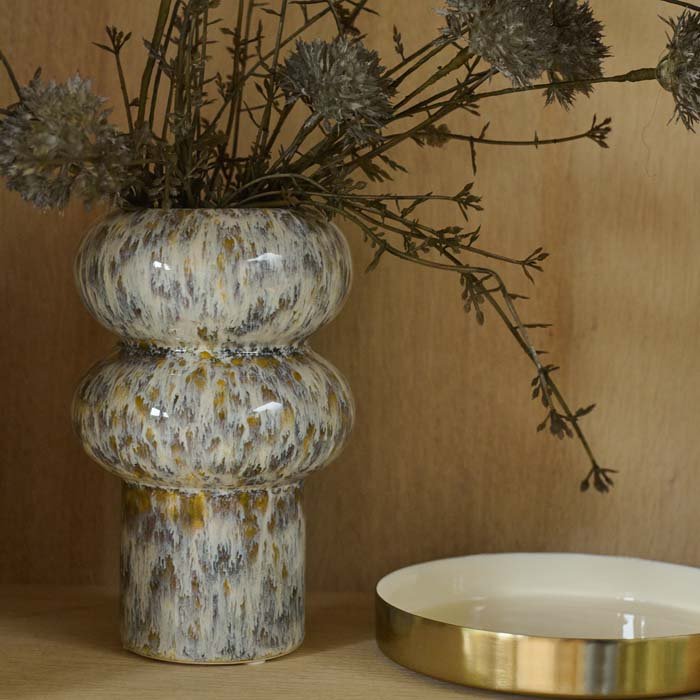 The Tanda Stoneware Vase, a a ridged cylindrical vase with a speckled glaze in contrasting warm brown and cream tones.