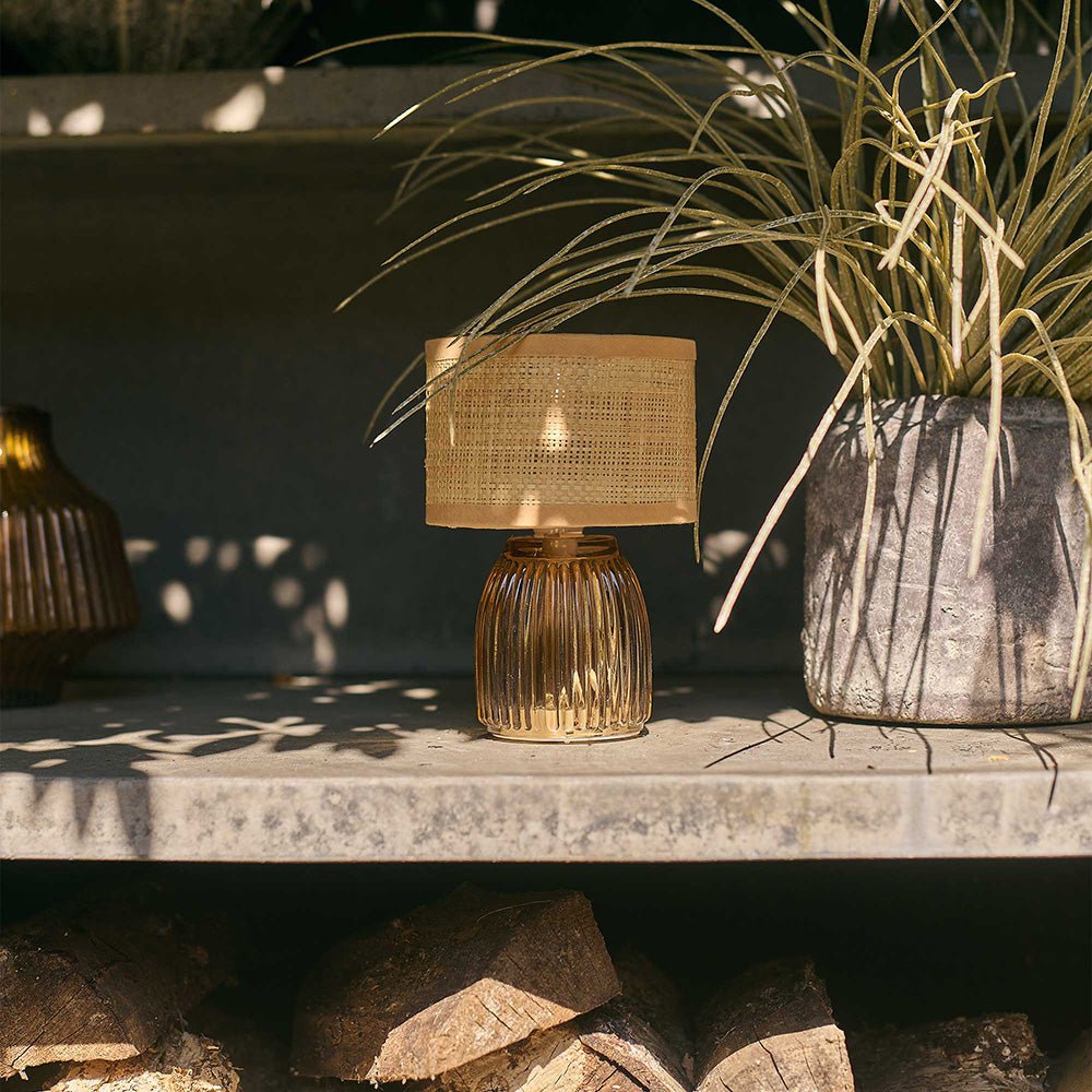 Croft Portable Table Lamp - a small cordless lamp with a glass base styled in a garden.