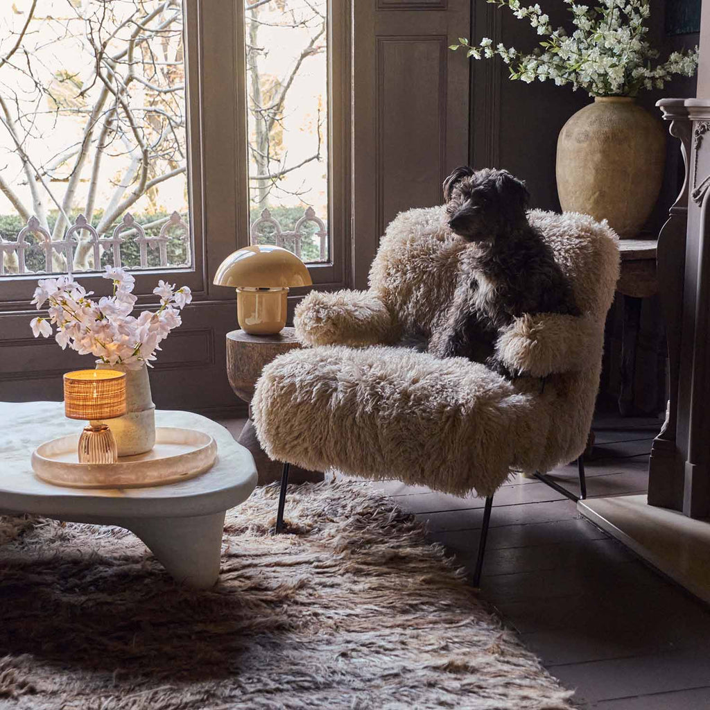 Selma faux fur armchair upholstered in soft cream faux fur with a curved contemporary silhouette, rounded backrest and generously cushioned seat. Luxury accent chair designed for living rooms, bedrooms and reading corners, bringing warmth, texture and comfort while adding sculptural form and understated elegance to modern and eclectic interiors.