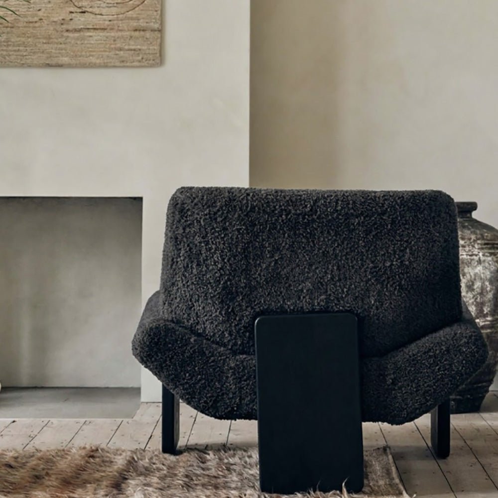 Back view of the Abigail Ahern Axel Faux Shearling Accent Chair in rich charcoal grey, featuring a distinctive modern silhouette with softly curved lines and plush, tactile upholstery. A statement accent chair that adds warmth, texture and personality to modern, eclectic interiors, ideal for a sitting room, bedroom or stylish home office.
 