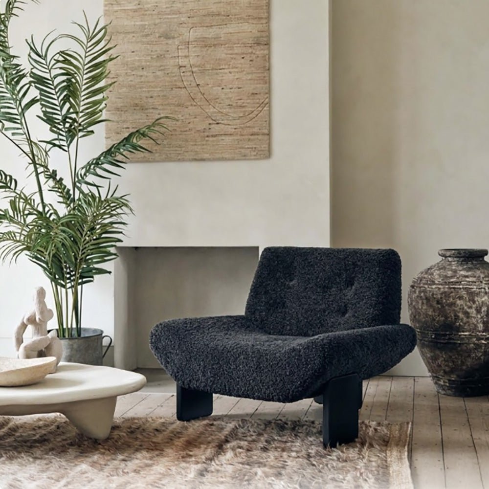 Abigail Ahern Axel Faux Shearling Accent Chair in rich charcoal grey, featuring a distinctive modern silhouette with softly curved lines and plush, tactile upholstery. A statement accent chair that adds warmth, texture and personality to modern, eclectic interiors, ideal for a sitting room, bedroom or stylish home office.