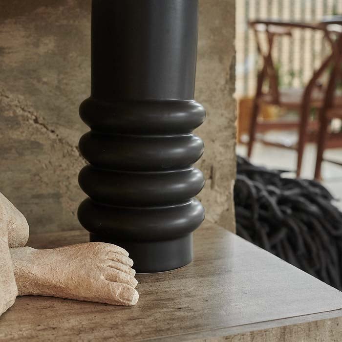A close up of the Julia Table Lamp, a detail of the abstract ribbed black ceramic base.