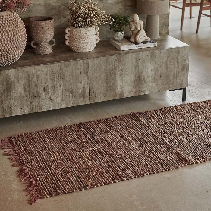 A brown woven leather runner in front of concrete-look console table.