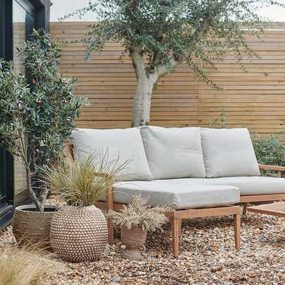 Wood-effect outdoor three seater sofa in garden.