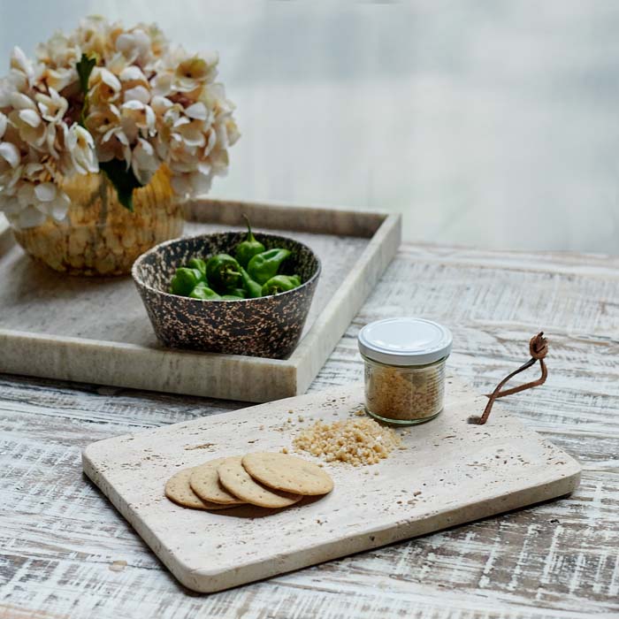 Travertine serving board set on a wooden table.