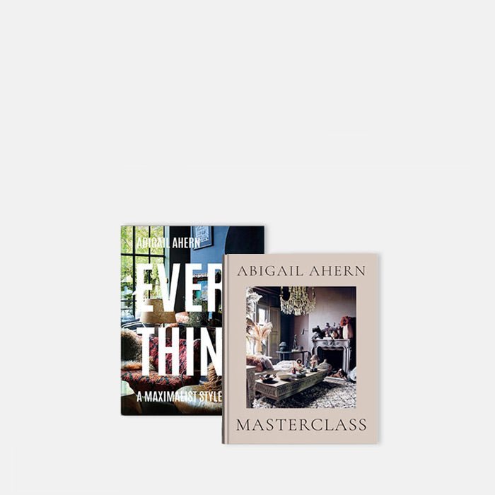 Cutout image on a white background of two hardback books by Abigail Ahern with images of her interiors overlapping.