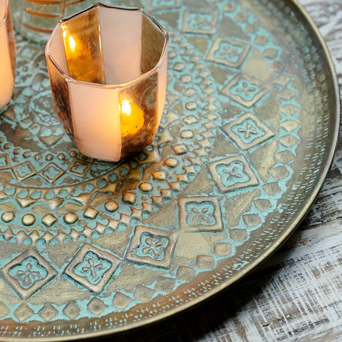 Bronze, decorative tray with a glass tea light holder on top.