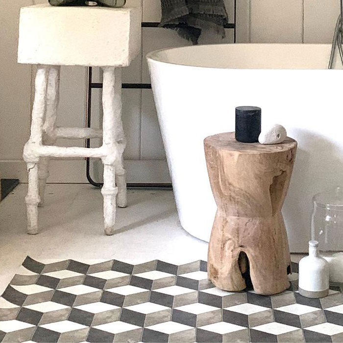 Monochrome patterned vinyl rug on the floor next to a bath tub