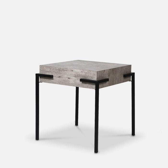 Faux concrete side table with square shape and four black metal legs.
