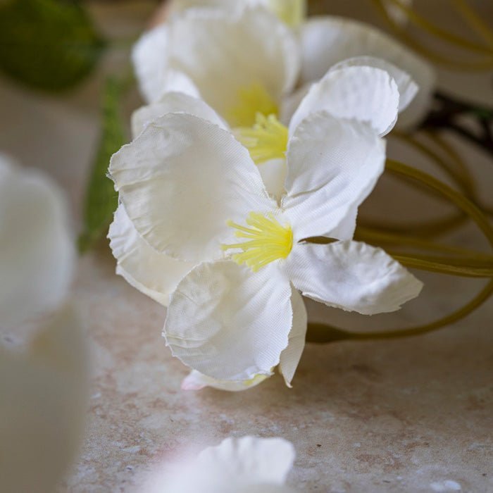 Detail image of the cream fabric flower heads on an artificial apricot blossom stem.