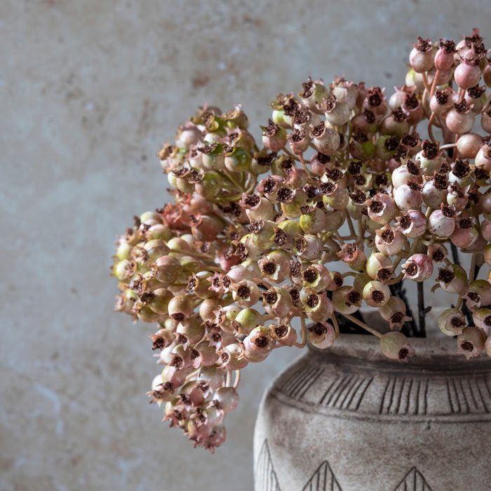 Close up image of the buds on an arrangement or artificial rose hip bunch stems in blush.