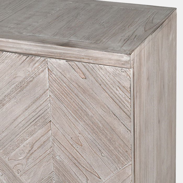 A closeup of the Astor Console Table, a sideboard with 4 doors and 12 shelves in a herringbone wooden tiled pattern.