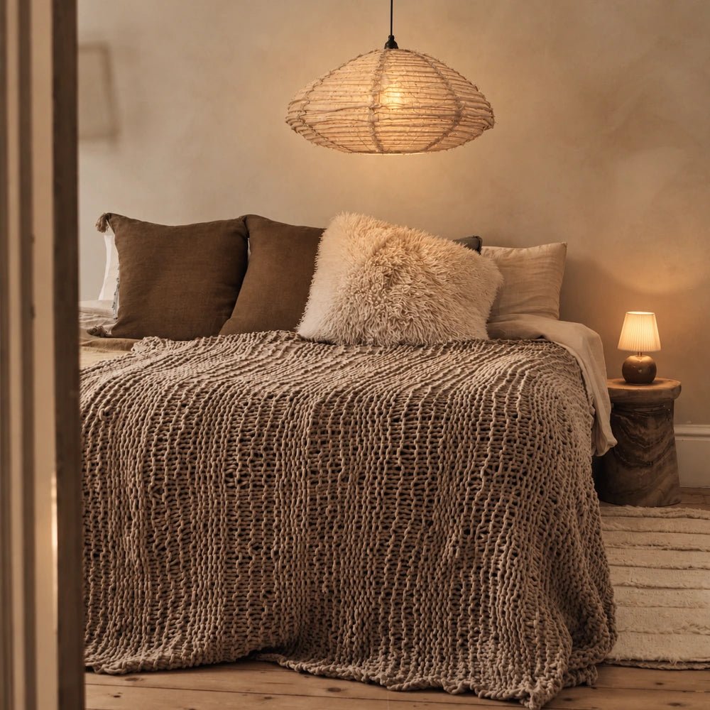 Atmore Fabric Pendant Light with softly gathered neutral shade, hanging above a dining table in a warm contemporary interior with natural textures.