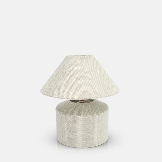 White and cream woven linen table lamp, with tapered cone shade and round base.