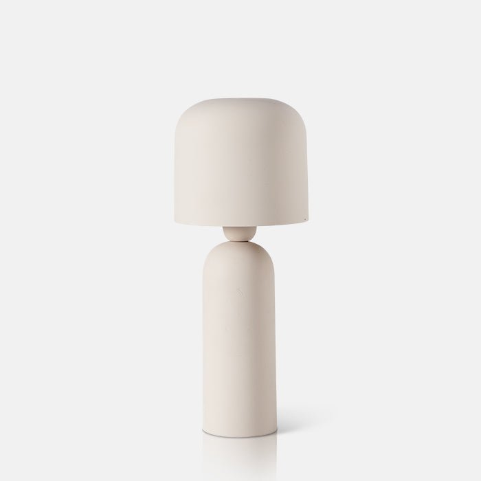 A cutout of the Barkly Table Lamp. A sleek matte cream metal table lamp with curved shade and smooth tapered base.