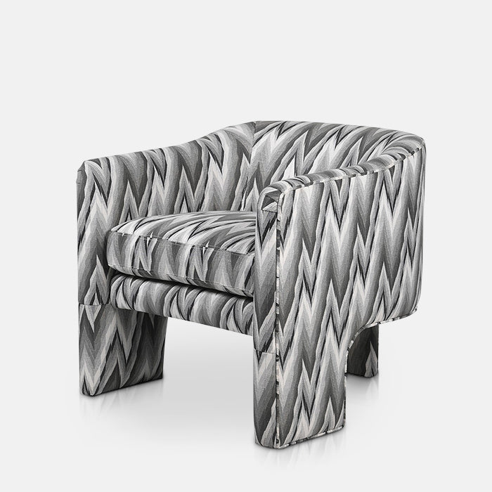 Curved armchair with three legs in a grey zig zag fabric