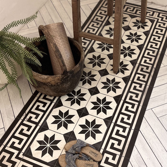 Decorative black and white tiled pattern of a vinyl runner with a table on top