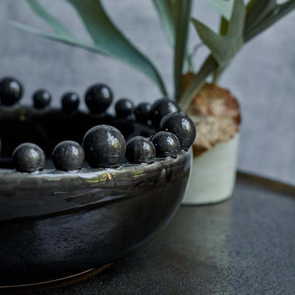 Small decorative balls around the rim on a glossy black bowl