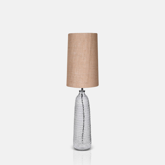 Tall table lamp with a clear glass base and cylindrical brown lampshade
